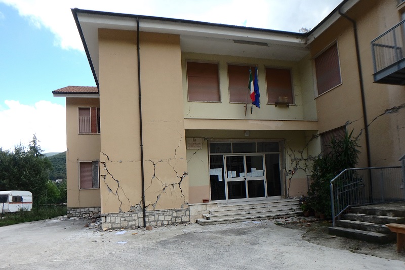 picture of slightly demolished building with a Italain and EU flag on it